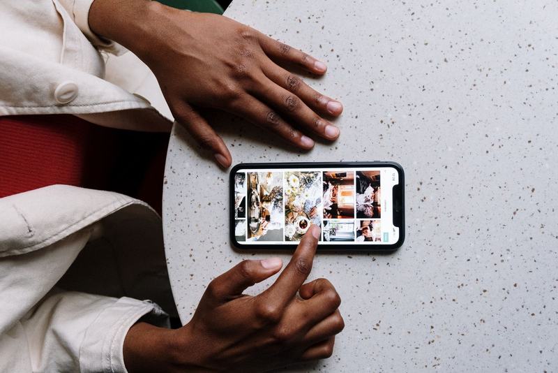 Overhead view of two hands using a smartphone on a speckled tabletop